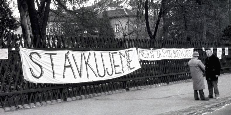 Transparent na plotě areálu přírodovědecké fakulty v době Sametové revoluce. 