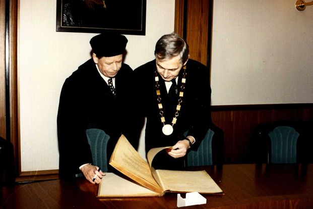 Václav Havel se zapisuje do pamětní knihy Masarykovy univerzity, vpravo tehdejší rektor MU Eduard Schmidt. Foto: Archiv MU.